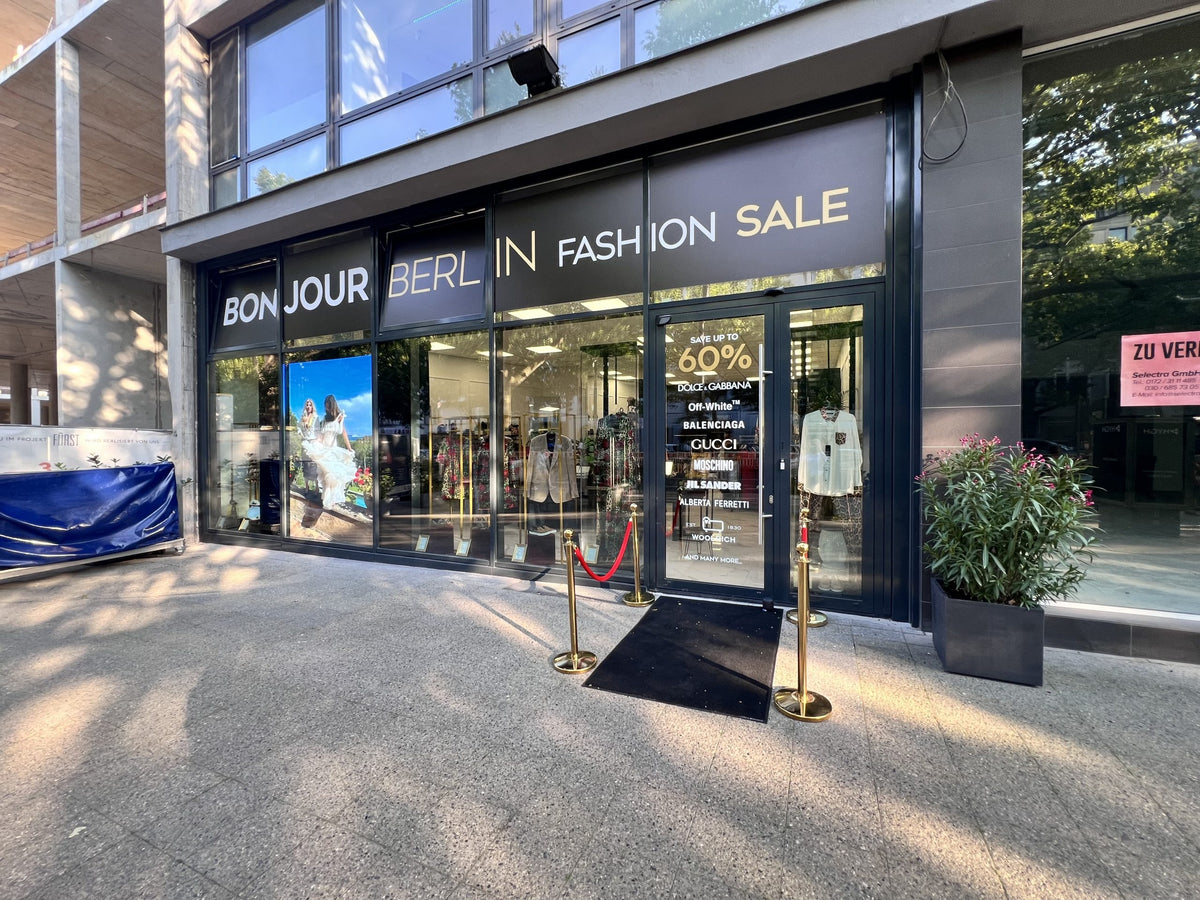 Außenansicht des Bonjour Berlin High Fashion Geschäfts. Die moderne Fassade mit großen Fenstern präsentiert stilvoll die exklusive Mode von Dolce & Gabbana. Das ansprechende Schaufenster zieht die Blicke der Passanten an und lädt sie ein, das Geschäft zu betreten.